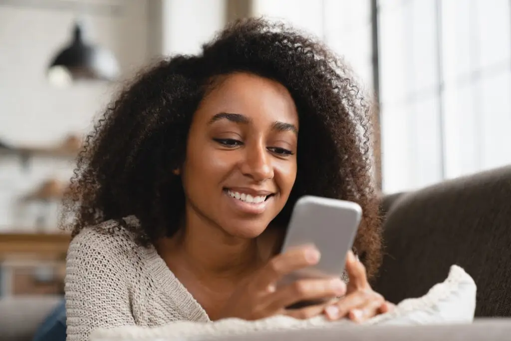 Girl relaxing at home, using smart phone, browsing news e-mails, social media online, chatting