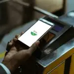 Close-up view of businessman using Google Pay paying for public transport